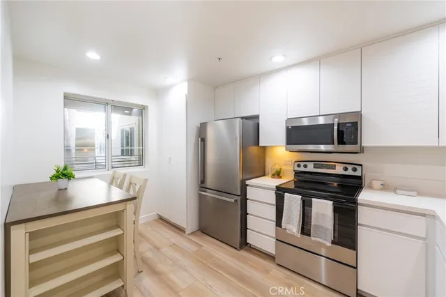 a kitchen with appliances a counter space and refrigerator