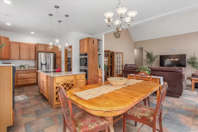 a large kitchen with kitchen island a dining table and stainless steel appliances