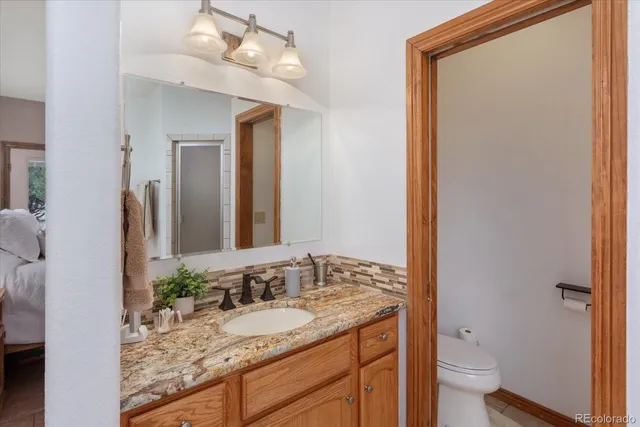 a bathroom with a granite countertop sink and a mirror