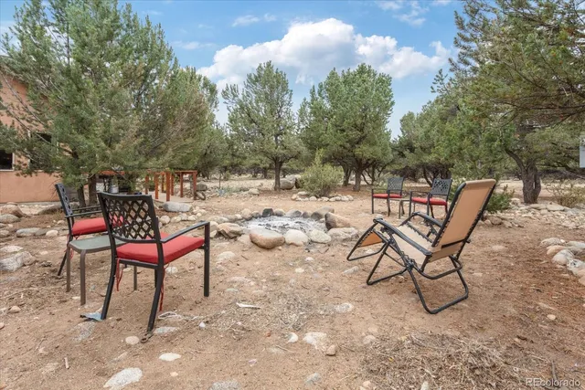 a view of a backyard with wooden fence and a bench