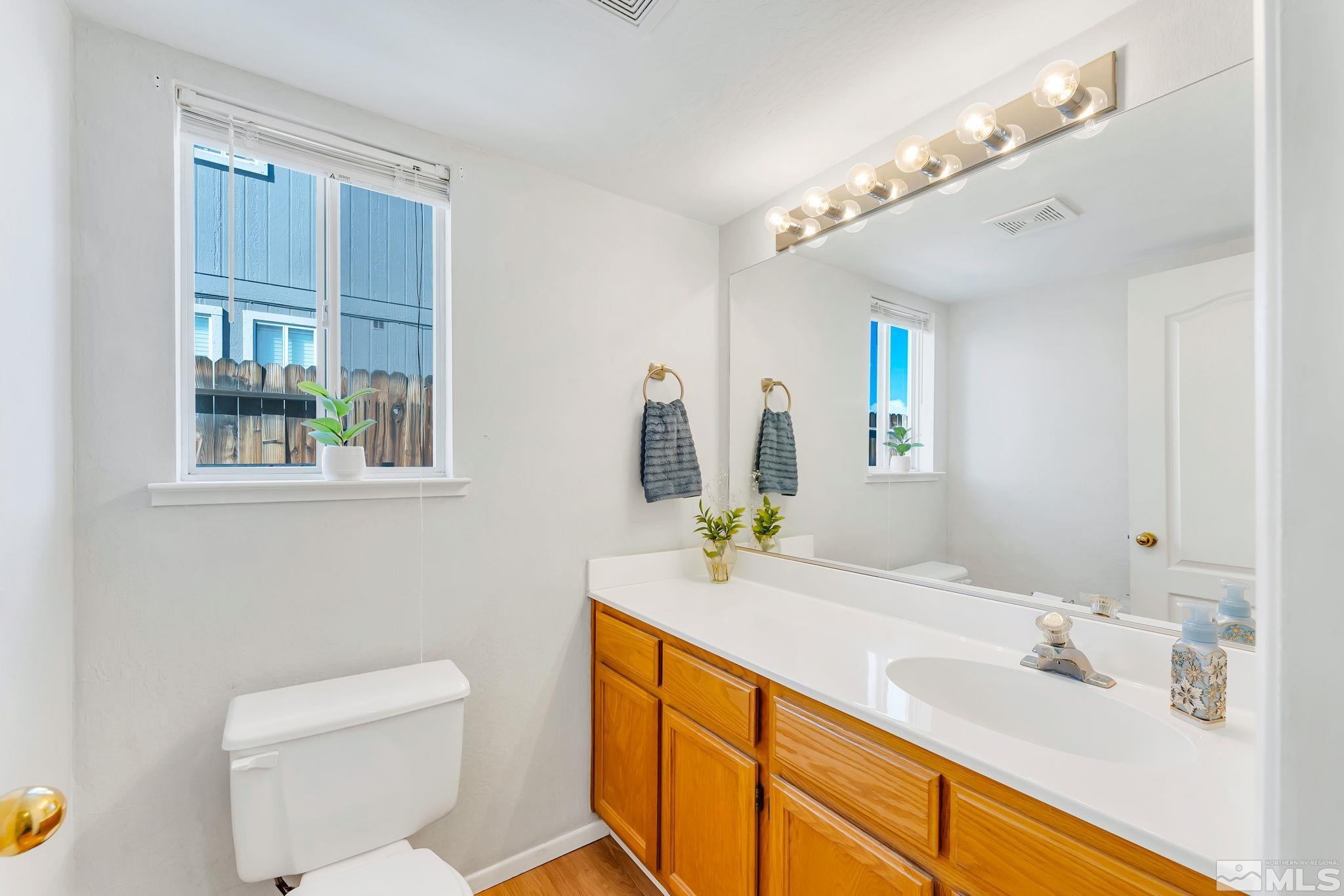 6580 Fall River Circle Reno, NV 89523 - Photo 22 of 36 a bathroom with a granite countertop sink a toilet and mirror