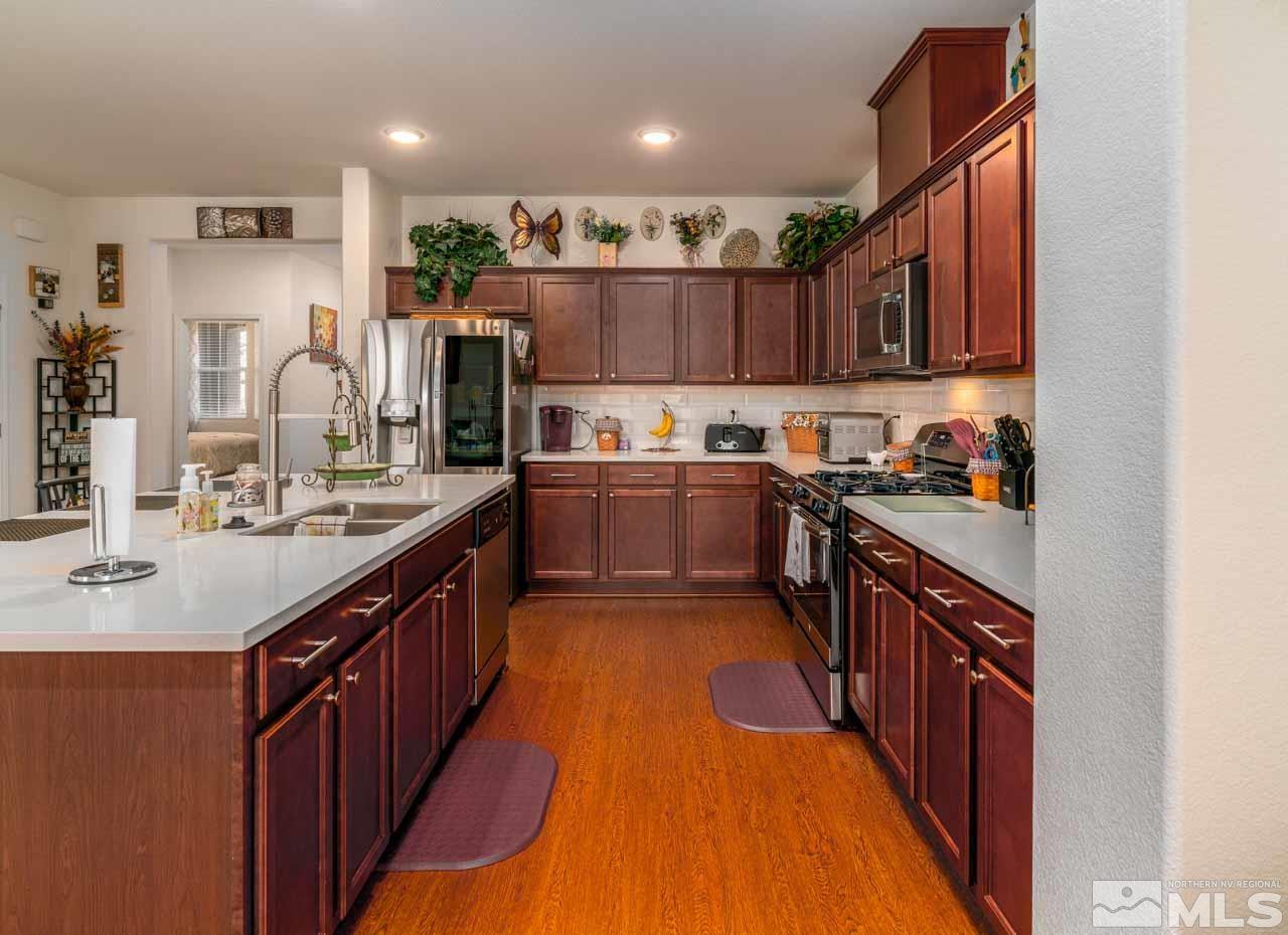 9341 Pond Court Reno, NV 89506 - Photo 11 of 30 a kitchen with kitchen island granite countertop a sink a counter top space stainless steel appliances and cabinets
