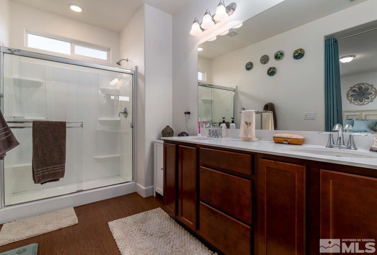 9341 Pond Court Reno, NV 89506 - Photo 16 of 30 a bathroom with a double vanity sink a mirror and shower