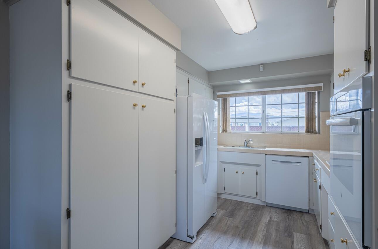 607 La Mesa Drive Salinas, CA 93901 - Photo 15 of 34 a view of a kitchen with white cabinets and wooden floor
