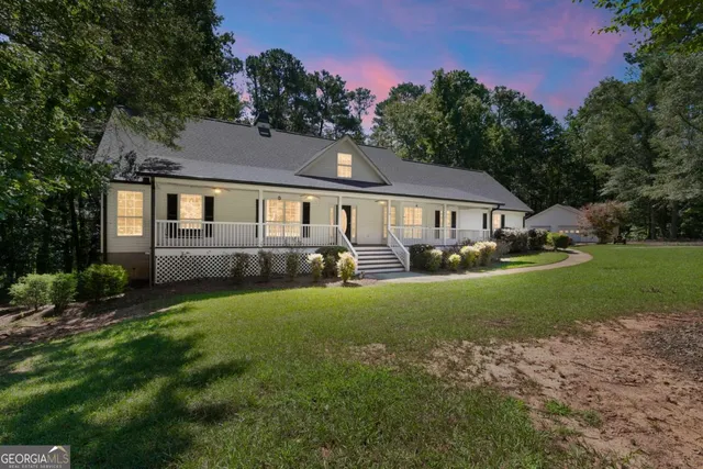 a front view of a house with yard and green space