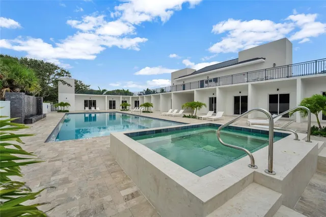 a view of a house with swimming pool and sitting area