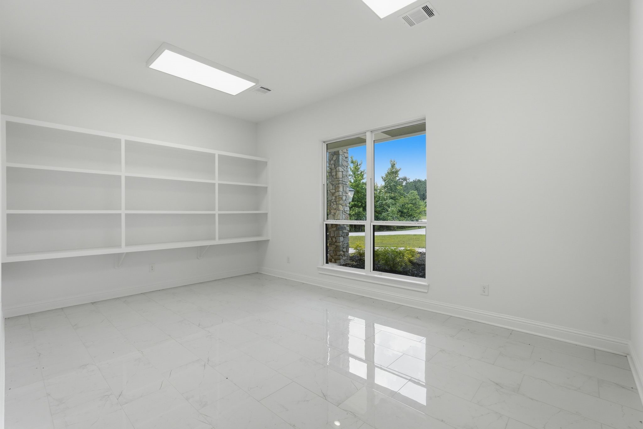 16081 Forest Mill Road Willis, TX 77378 - Photo 27 of 37 Designed for flexibility and organization, this bonus room showcases custom built-in shelving and ample space for a private office, library, creative studio, or additional living area.
