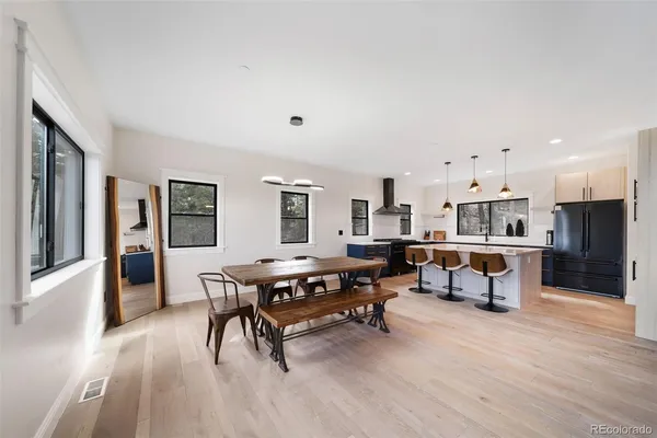 a living room with furniture and a dining table with wooden floor