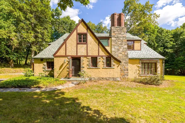 a view of a house with yard and sitting area