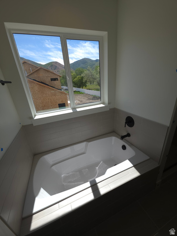 1267 West 2350 South Perry, UT 84302 - Photo 12 of 20 Soaking tub featuring a white finish, dark plumbing fixtures, and tiled surround