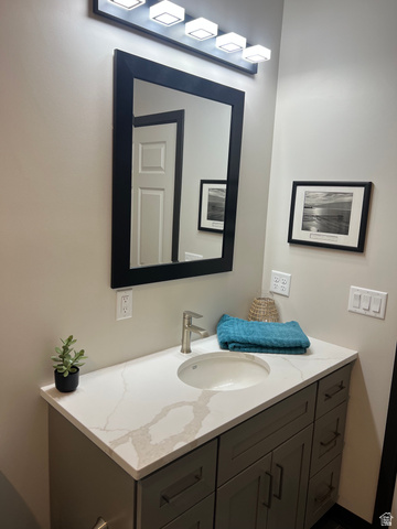 160 200 West Henefer, UT 84033 - Photo 21 of 25 Modern vanity featuring a light-toned countertop with veining, an undermount sink, and a brushed nickel faucet