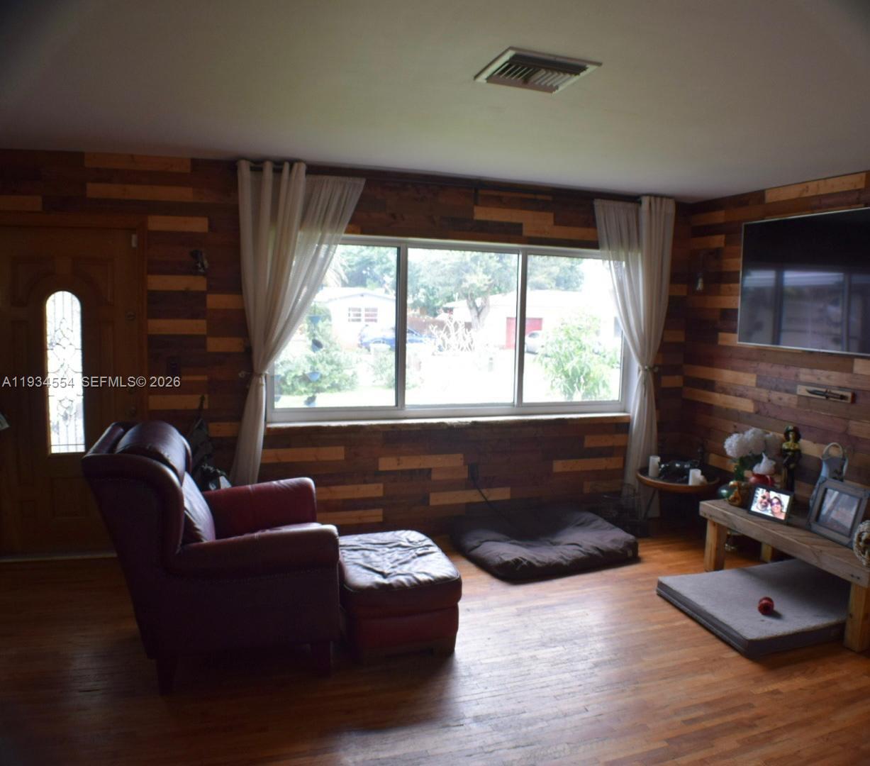 630 Northeast 165th Street Miami, FL 33162 - Photo 11 of 34 a living room with furniture fireplace and a flat screen tv