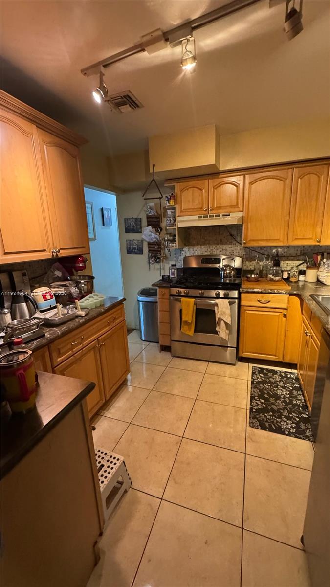 630 Northeast 165th Street Miami, FL 33162 - Photo 15 of 34 a kitchen with stainless steel appliances granite countertop a stove a sink and a refrigerator