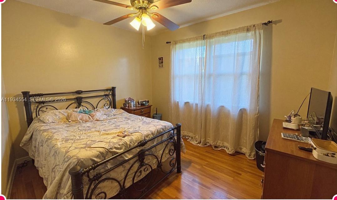 630 Northeast 165th Street Miami, FL 33162 - Photo 19 of 34 a bedroom with a bed and a chandelier