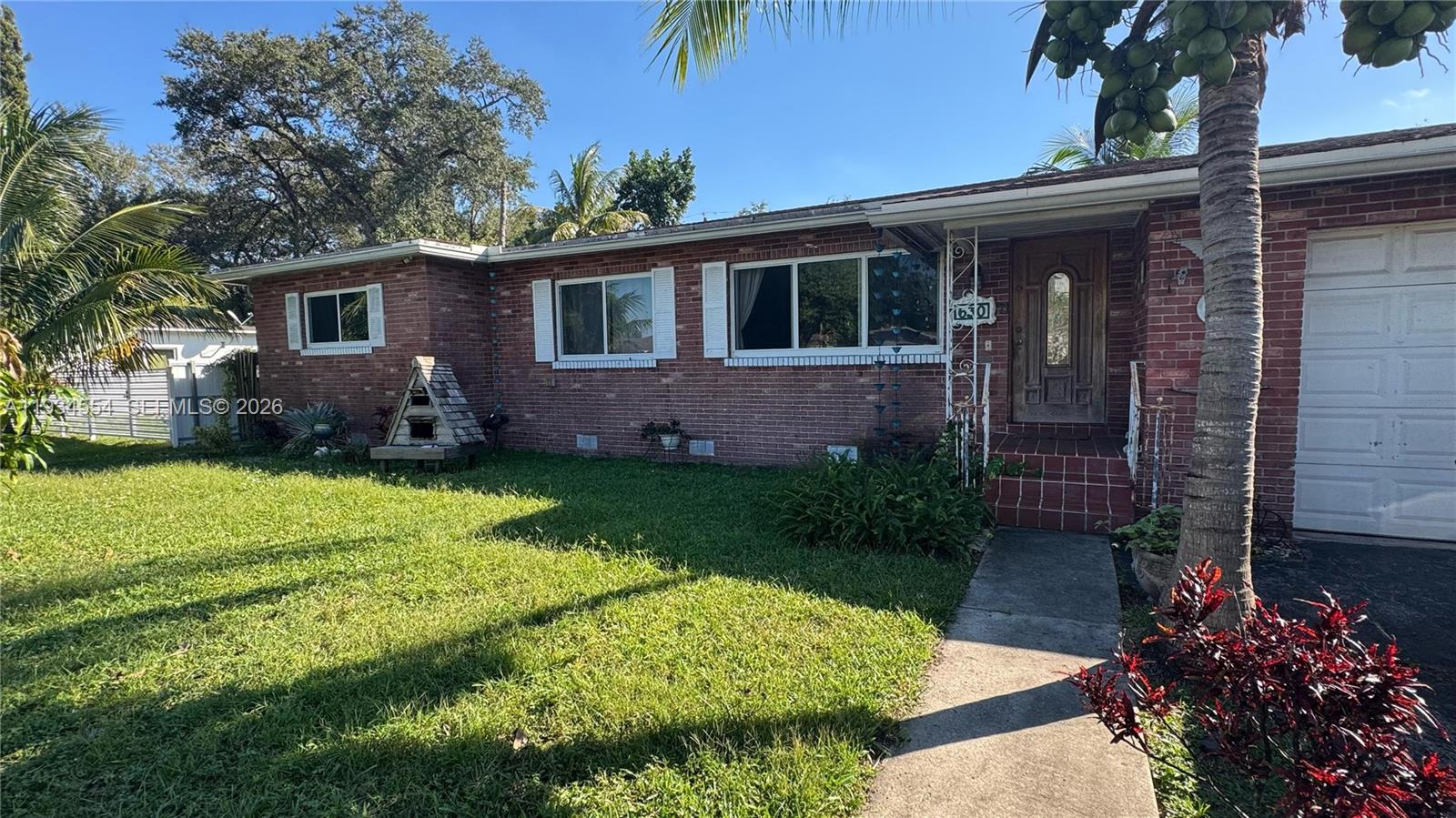 630 Northeast 165th Street Miami, FL 33162 - Photo 2 of 34 a front view of a house with a garden and plants