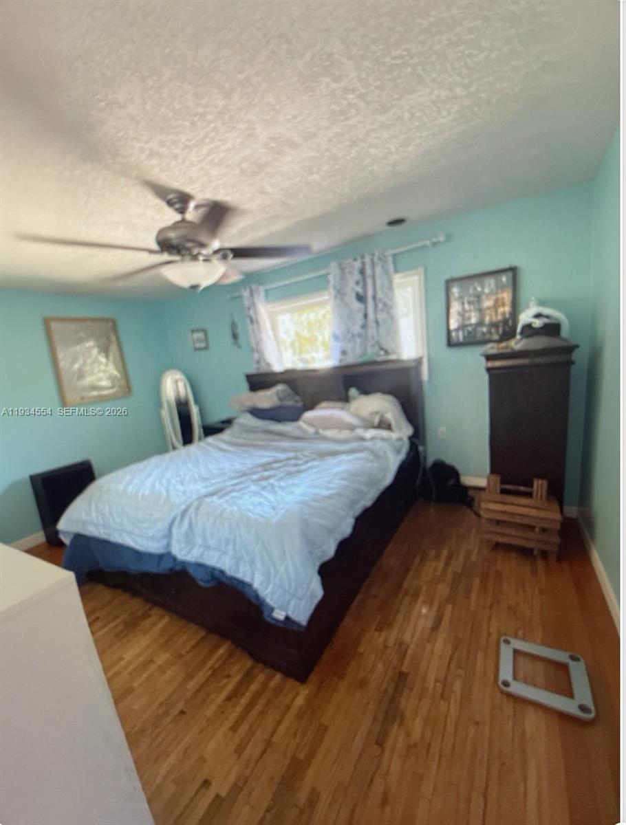 630 Northeast 165th Street Miami, FL 33162 - Photo 23 of 34 a bedroom with a bed and a flat tv screen on dresser