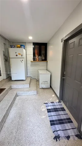 a bed room with a bed and a refrigerator