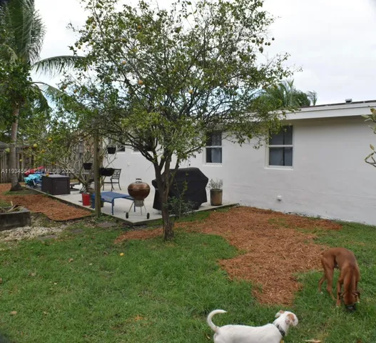a backyard of a house with table and chairs