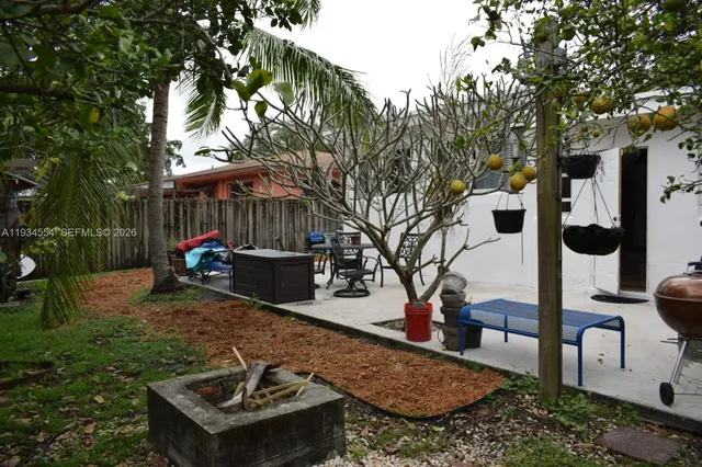 a backyard of a house with barbeque oven table and chairs