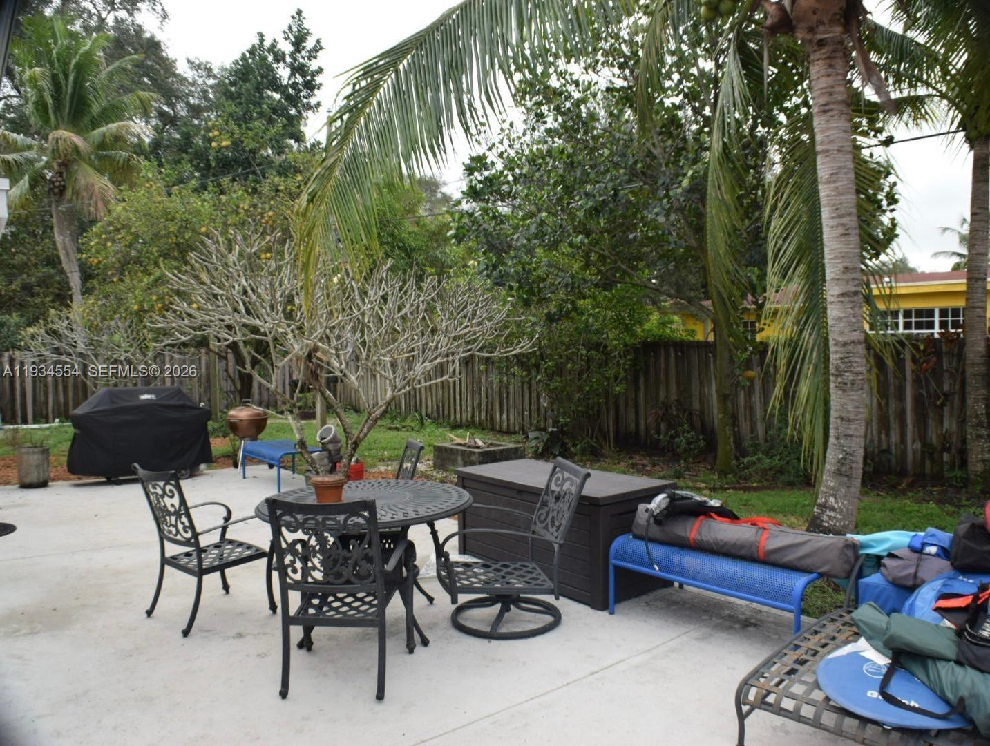 630 Northeast 165th Street Miami, FL 33162 - Photo 9 of 34 a backyard of a house with barbeque oven table and chairs