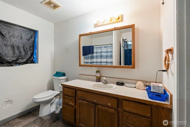 a bathroom with a toilet a sink and mirror