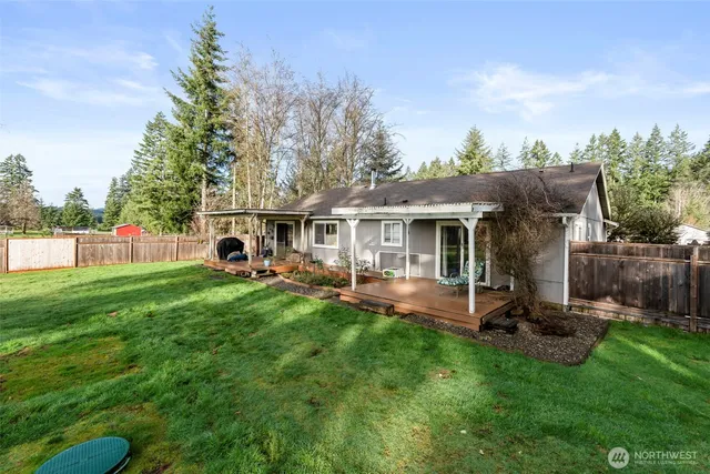 a view of a house with backyard and a tree