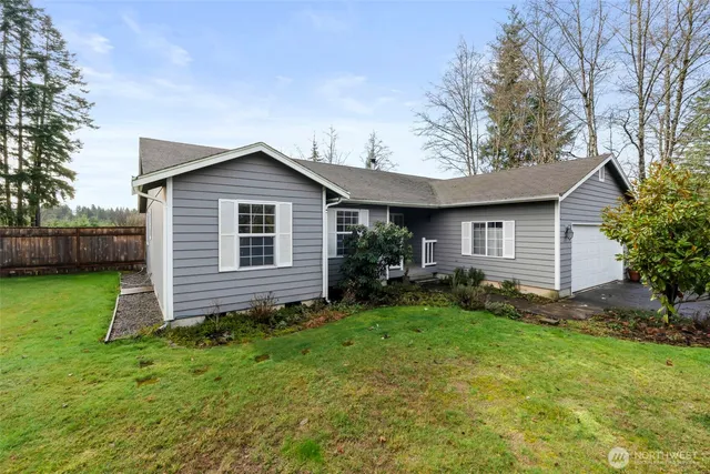 a view of a house with a yard potted plants and a large tree