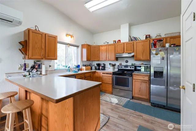 a kitchen with granite countertop a stove a sink and a refrigerator