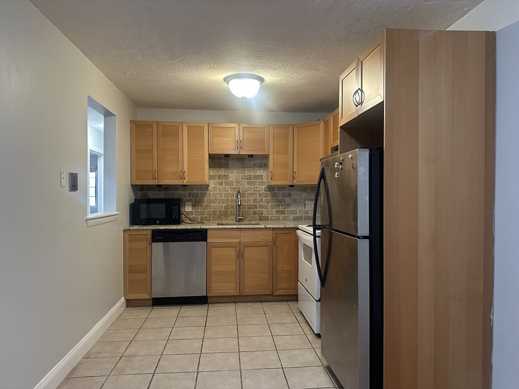 47 West Street, Unit C4 Randolph, MA 02368 - Photo 2 of 10 a kitchen with a refrigerator a sink and a stove top oven