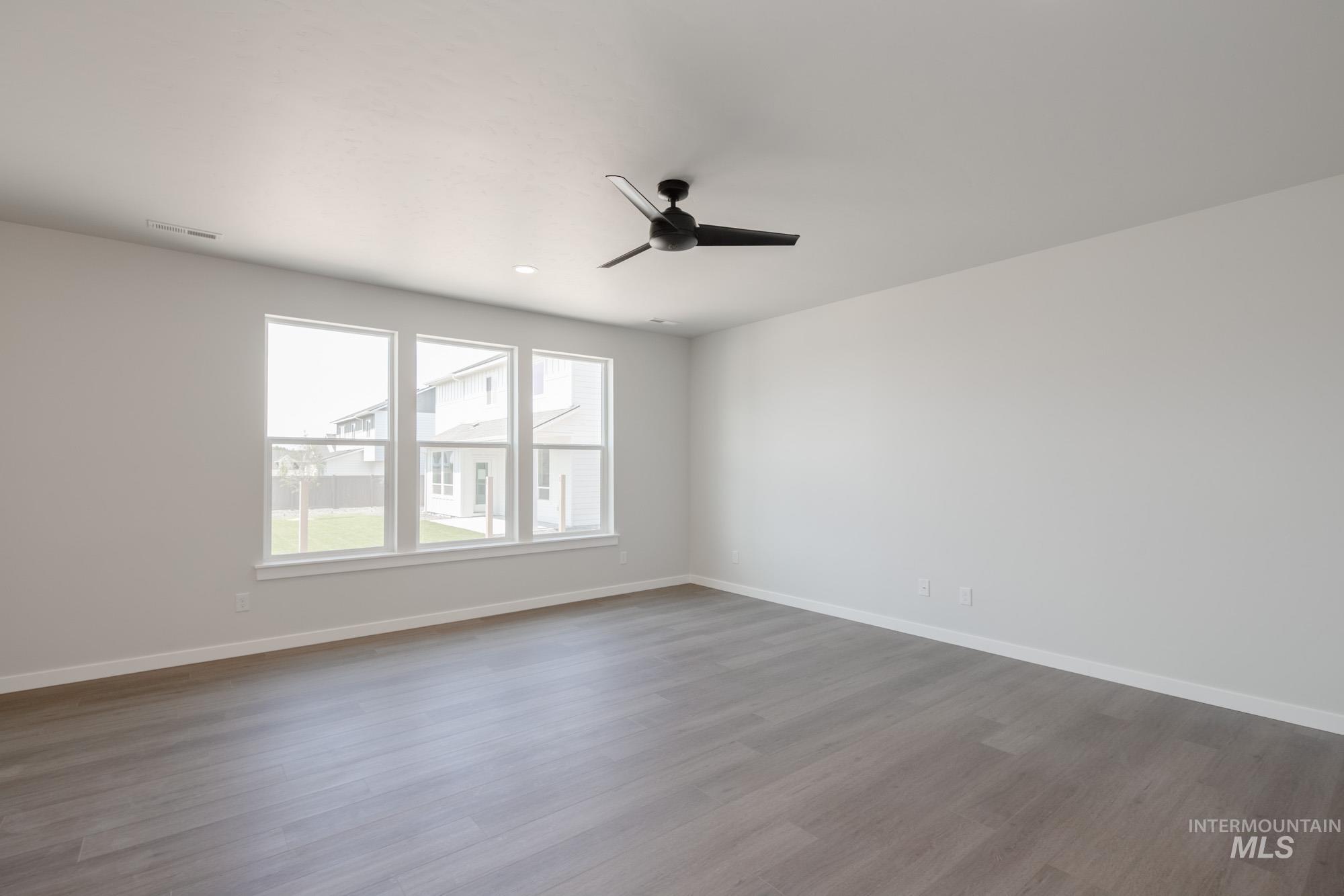6447 South Sunfish Way Boise, ID 83709 - Photo 13 of 29 Empty room with dark wood-type flooring and a ceiling fan