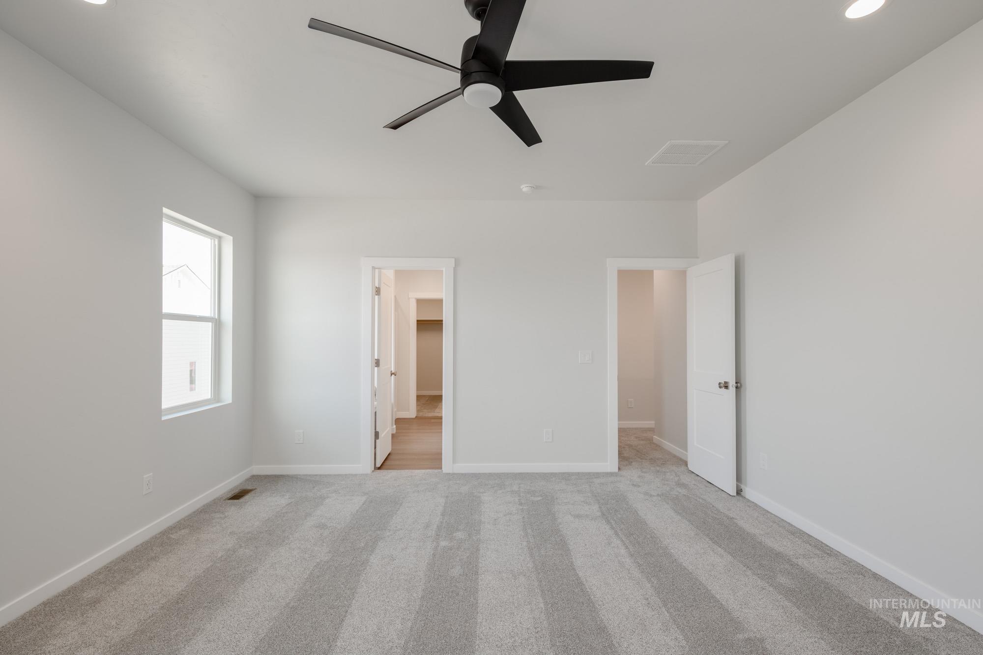 6447 South Sunfish Way Boise, ID 83709 - Photo 17 of 29 Unfurnished bedroom featuring light carpet, recessed lighting, a spacious closet, and a ceiling fan