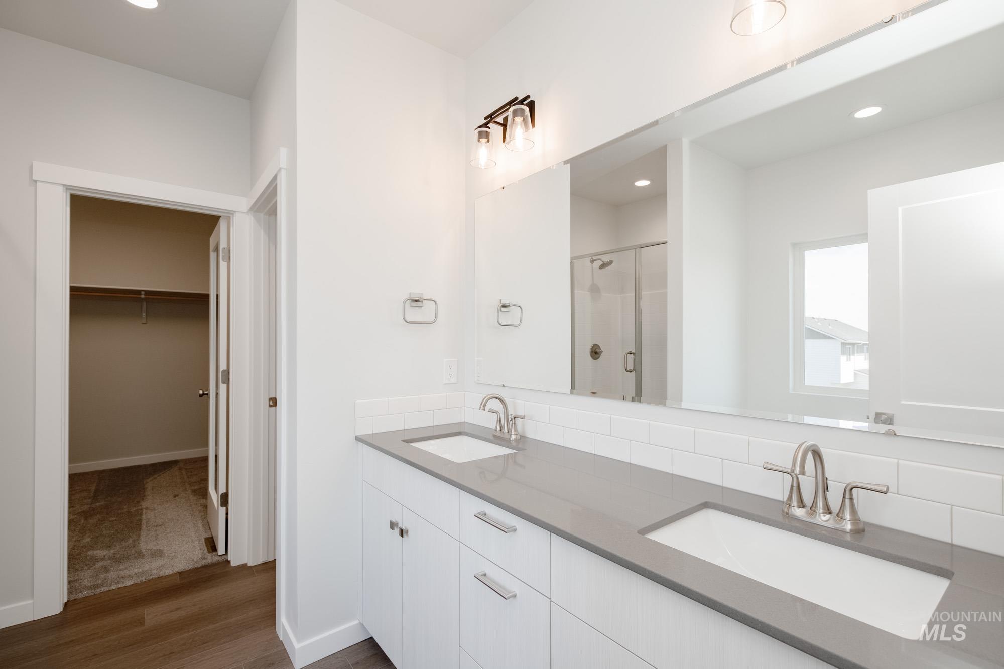 6447 South Sunfish Way Boise, ID 83709 - Photo 18 of 29 Bathroom with a stall shower, wood finished floors, double vanity, recessed lighting, and a spacious closet