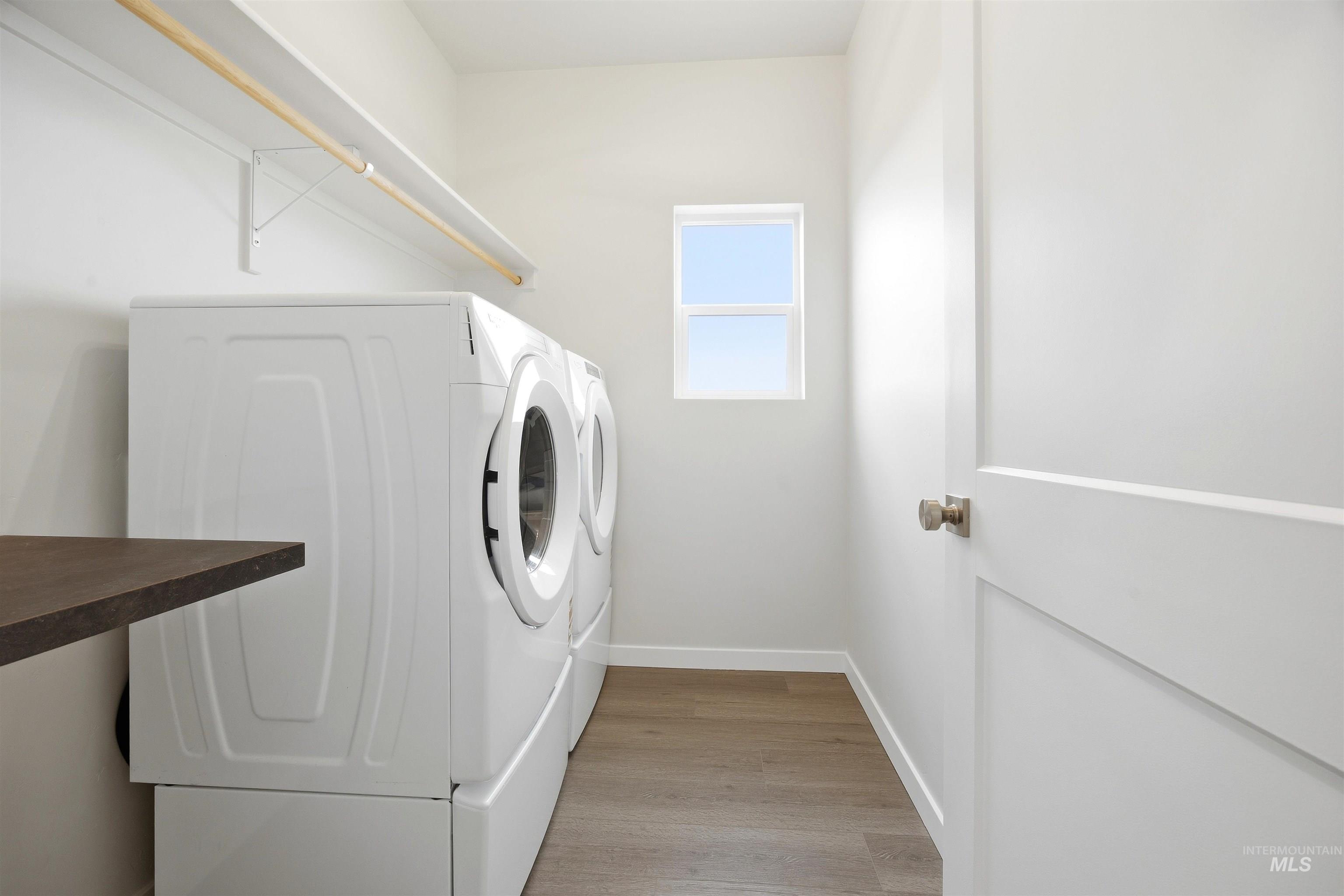 6447 South Sunfish Way Boise, ID 83709 - Photo 26 of 29 Dedicated laundry area featuring a built-in shelf with a hanging rod, a dark countertop, wood-finish flooring, and a single window