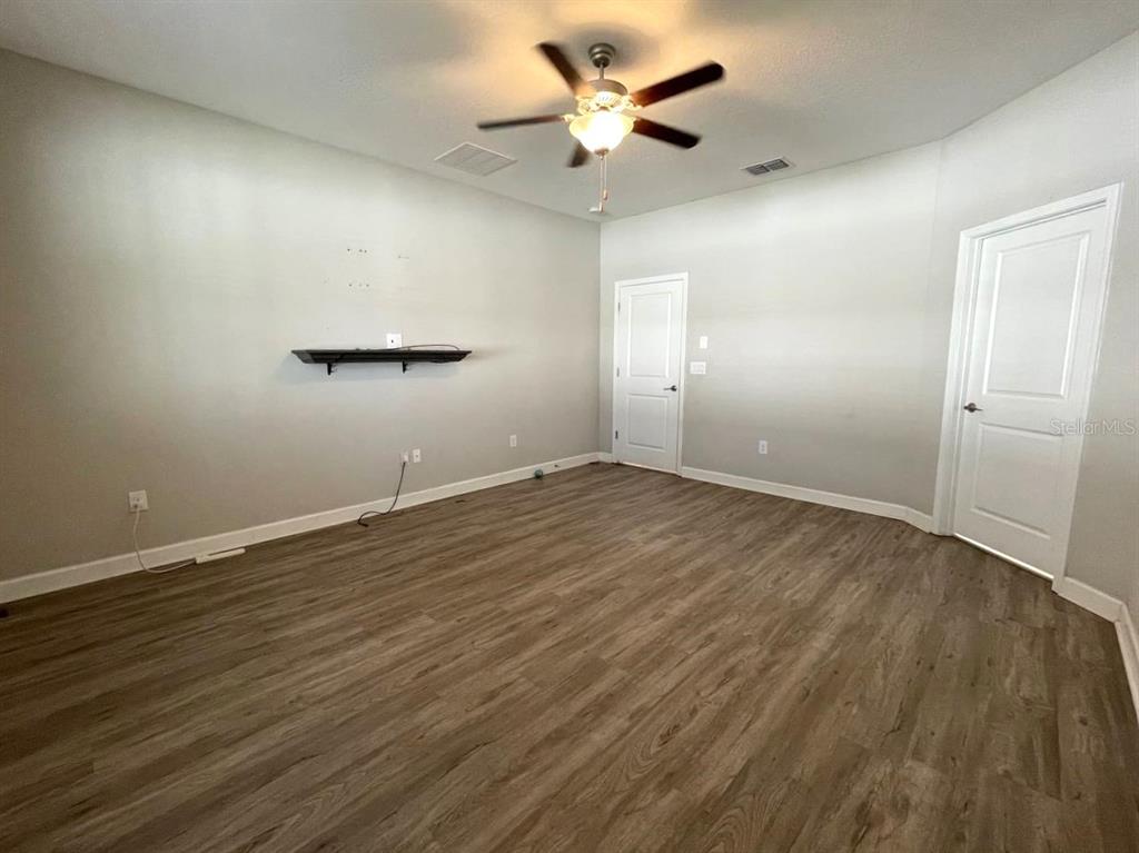 13339 Orca Sound Drive Riverview, FL 33579 - Photo 14 of 32 an empty room with wooden floor and a ceiling fan