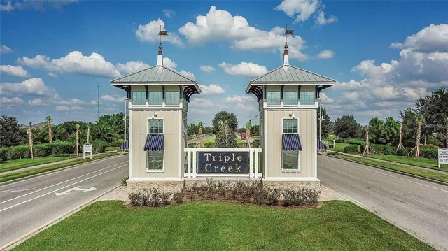 a view of a swimming pool with lawn chairs under an umbrella with wooden floor