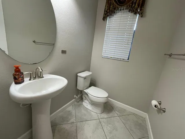 a bathroom with a sink a toilet and mirror