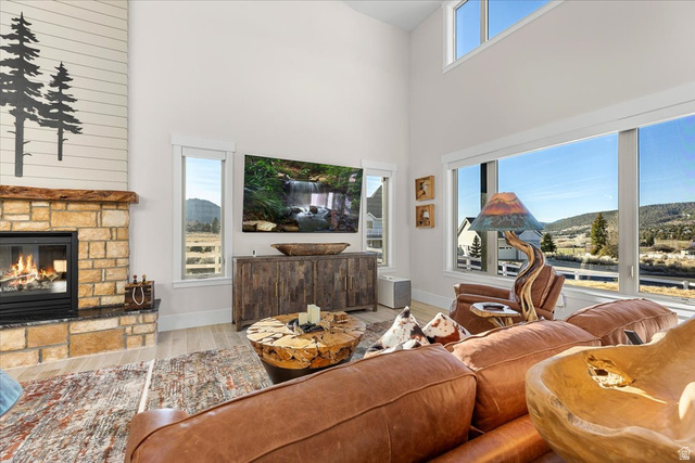 1210 East Bristle Cone Road Pine Valley, UT 84781 - Photo 5 of 54 Living room featuring wood finished floors, a fireplace, a high ceiling, and a mountain view