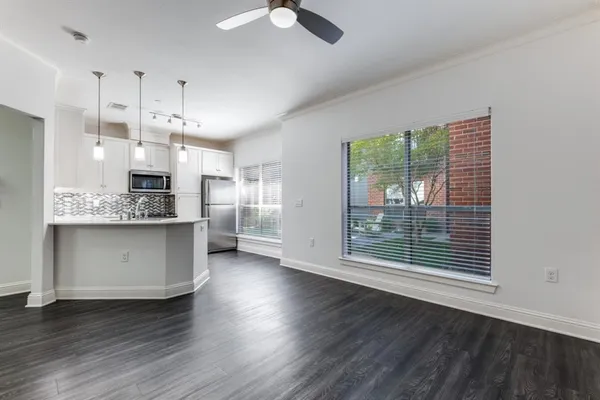 a kitchen with stainless steel appliances kitchen island wooden floors cabinets and a chandelier