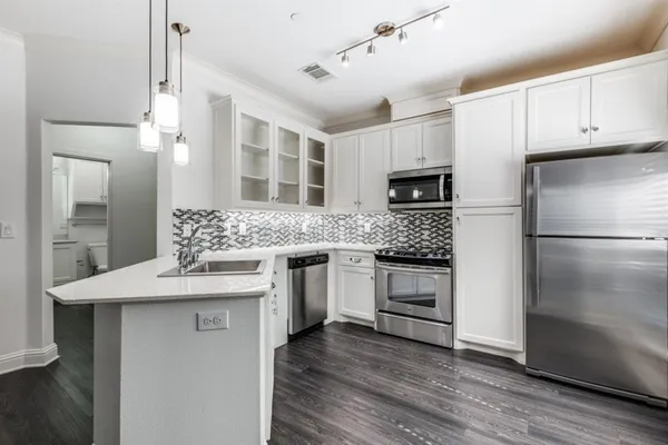 a kitchen with stainless steel appliances granite countertop a refrigerator and a stove top oven