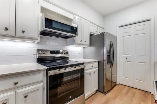 a kitchen with stainless steel appliances a stove microwave and refrigerator