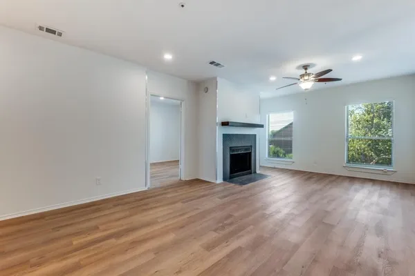 a view of an empty room with a fireplace and a window