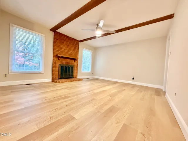 an empty room with fireplace and windows