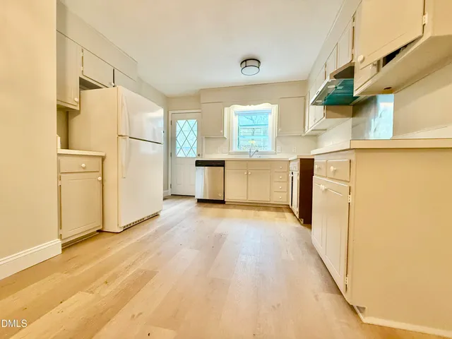 a view of a kitchen with wooden floor and electronic appliances