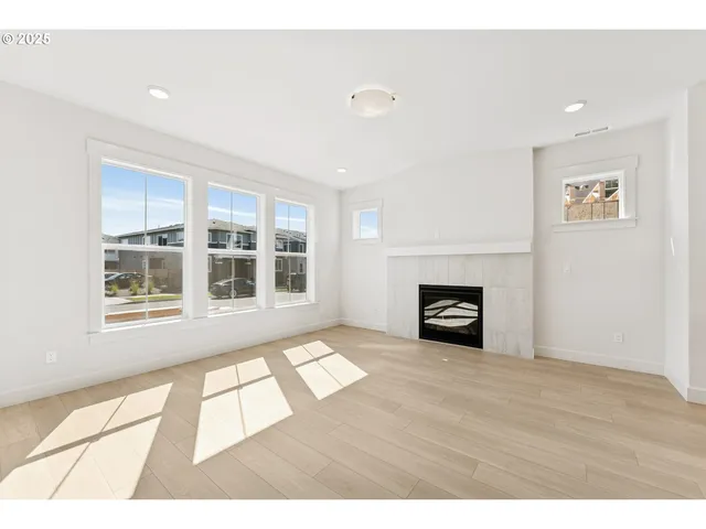 a view of an empty room with a fireplace and a window