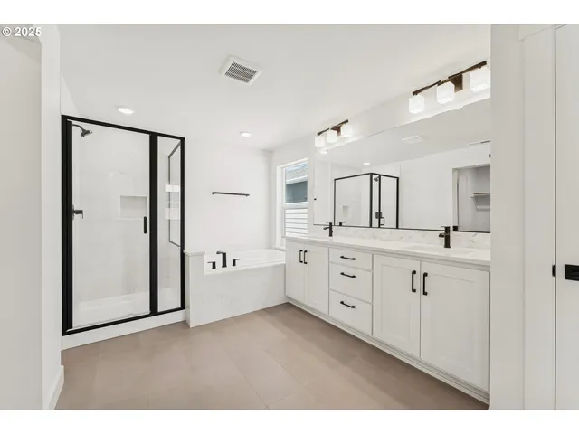a bathroom with a double vanity sink a mirror and a bathtub