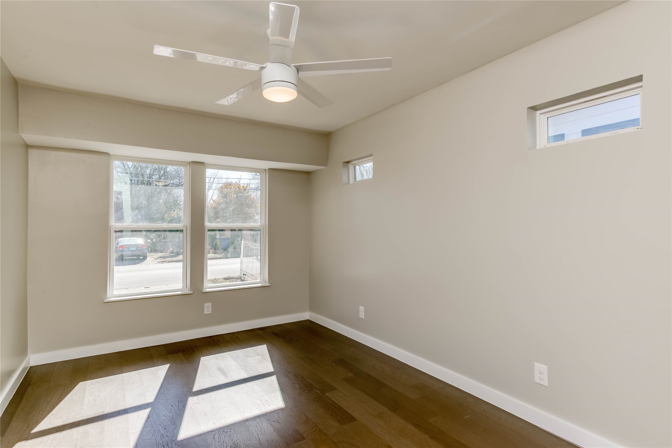 4702 Bandera Road Austin, TX 78721 - Photo 5 of 12 a view of an empty room with wooden floor and a window