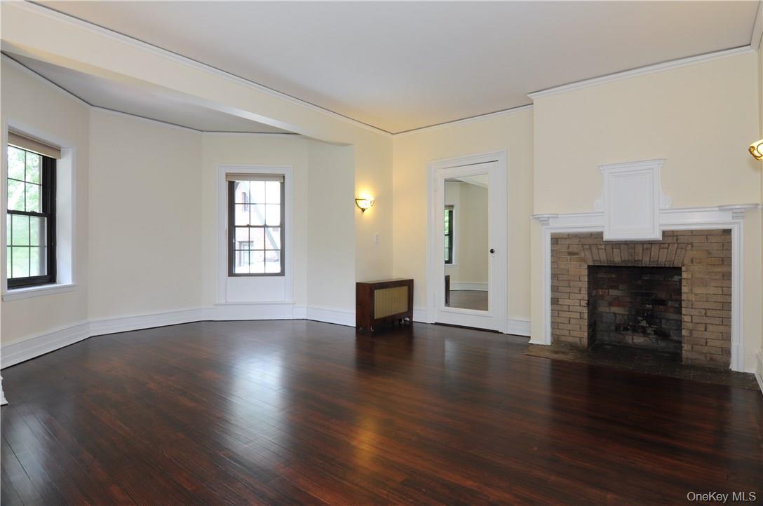136 Harriman Road, Unit 2 Irvington, NY 10533 - Photo 15 of 23 an empty room with wooden floor and fireplace