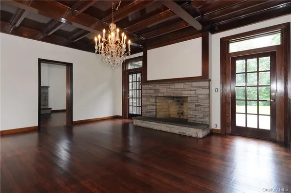 a view of a livingroom with wooden floor a fireplace and a window