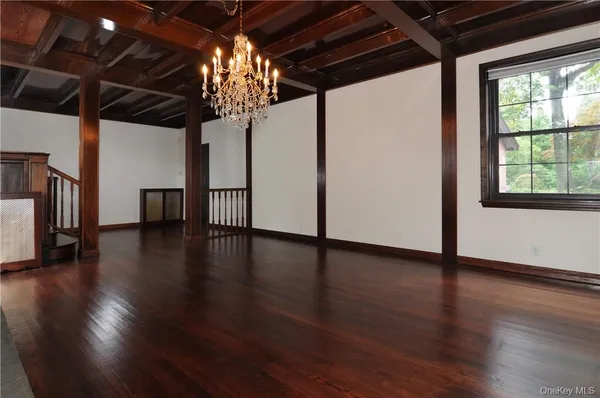 a view of a livingroom with wooden floor a ceiling fan and window