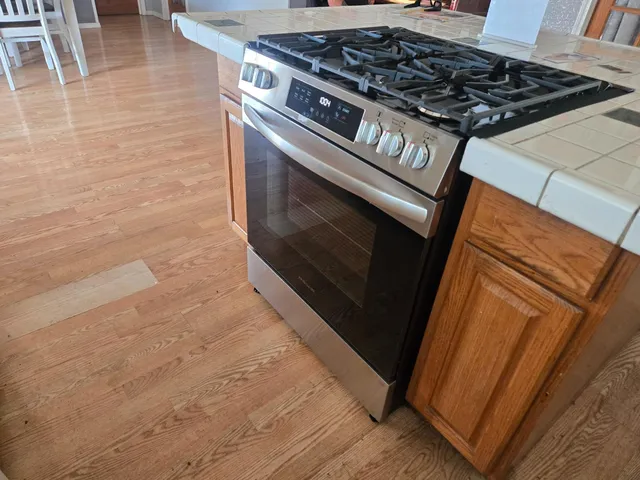 a stove top oven sitting inside of a kitchen